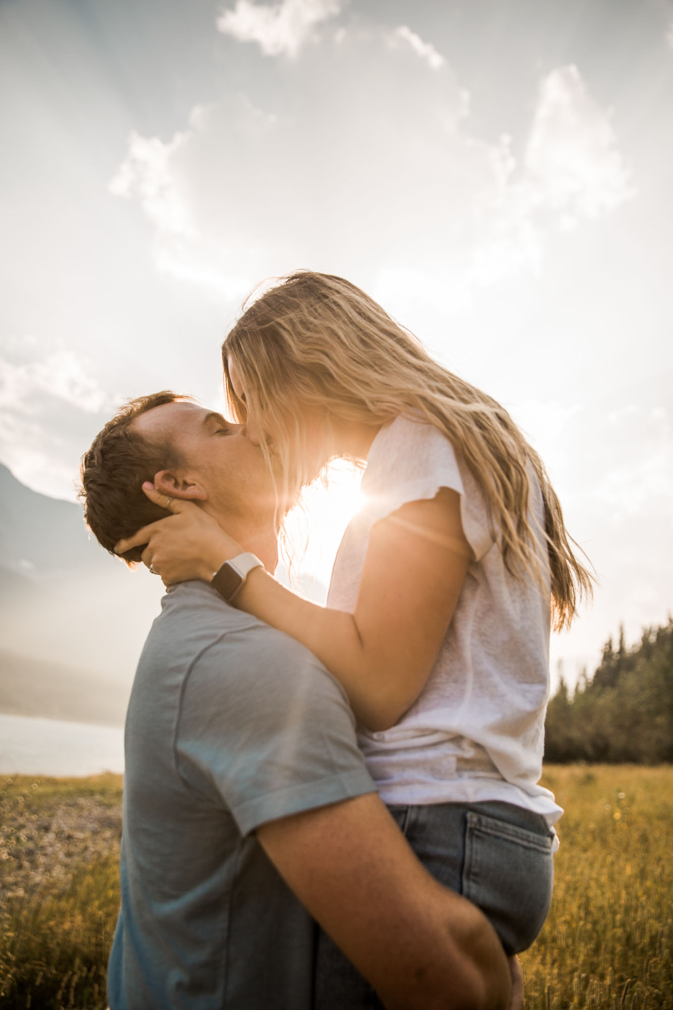 Calgary wedding and engagement photographer, couple by the water and mountains at sunset in Kananaskis Country
