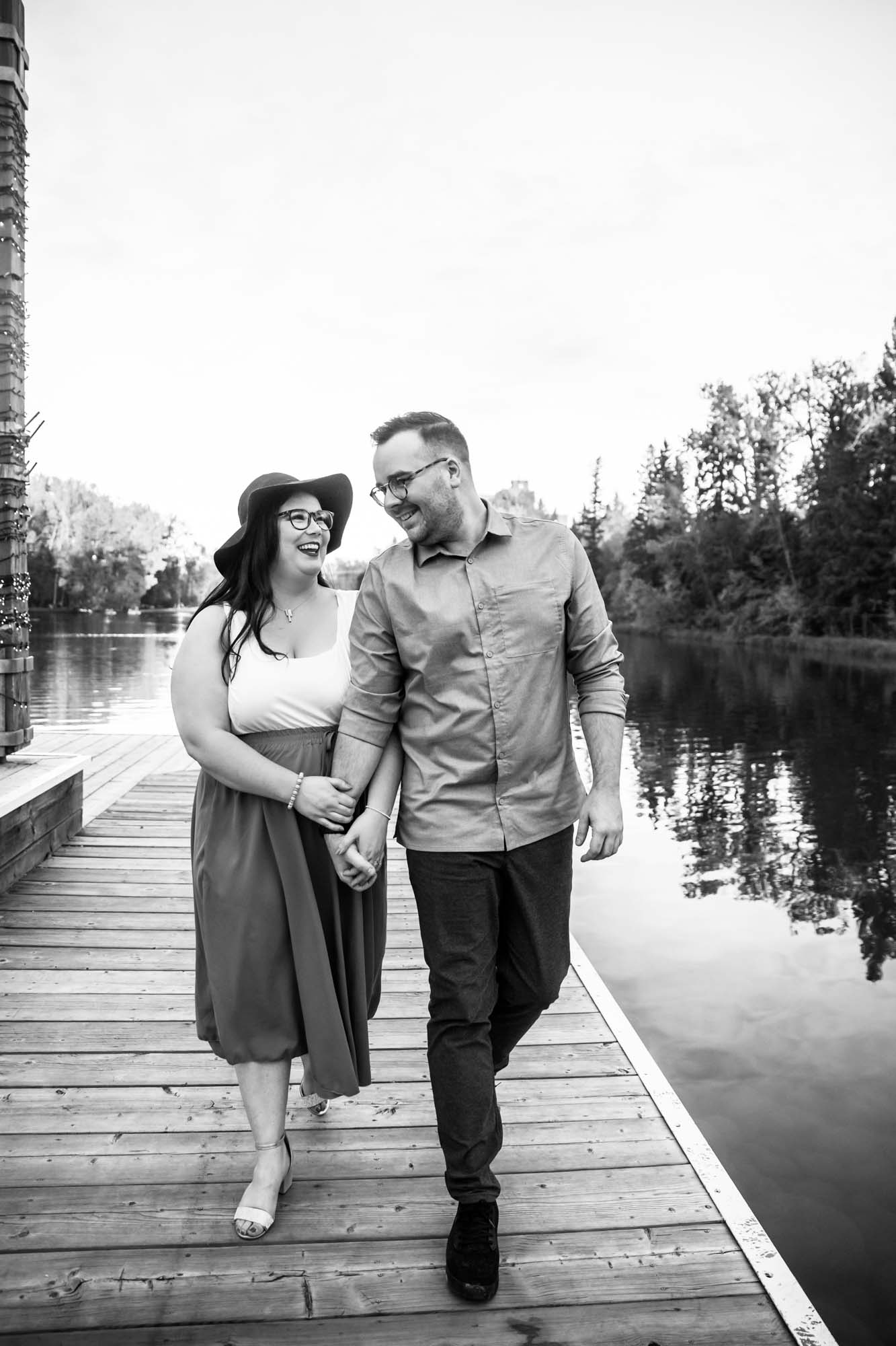 Calgary wedding photographer, engagement photos at Bowness Park, couple in front of the water and a beautiful orange sunset