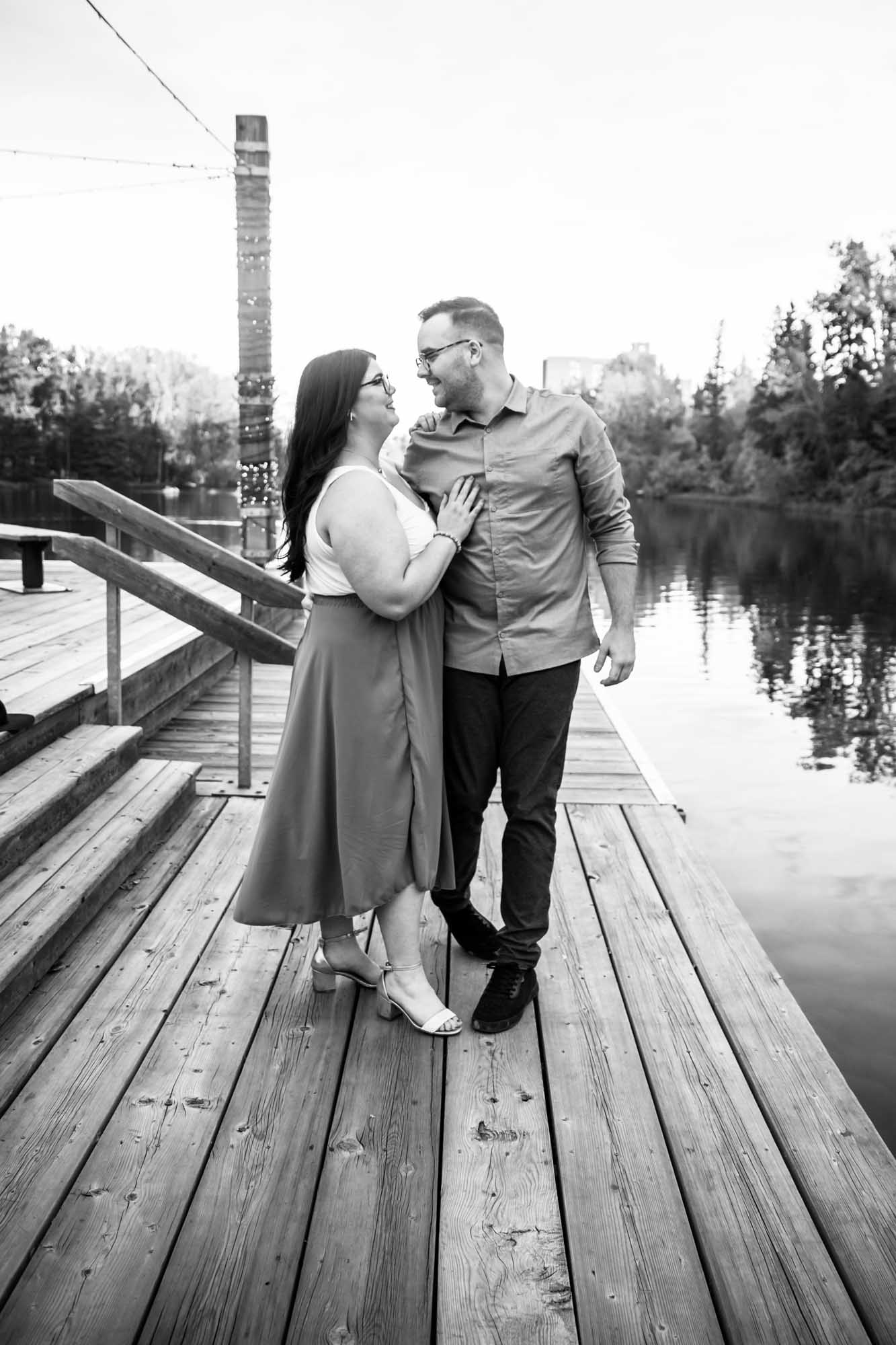 Calgary wedding photographer, engagement photos at Bowness Park, couple in front of the water and a beautiful orange sunset