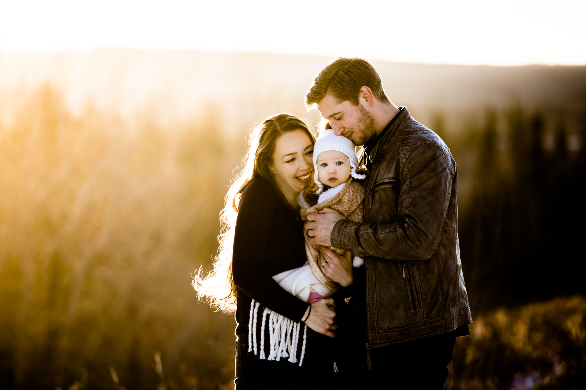 Calgary lifestyle family photographer, winter family photos at sunset at Weaslehead Flats, mom, dad and daughter in beautiful golden light