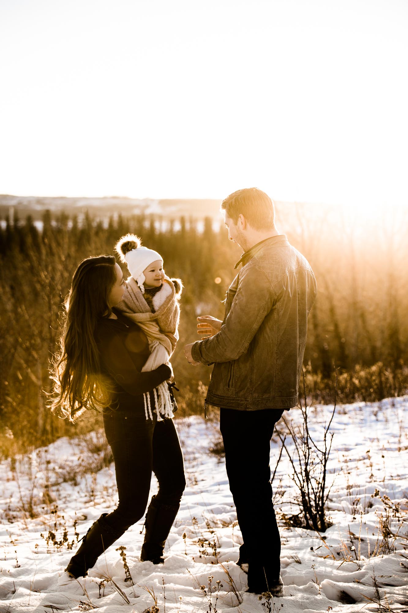 Calgary lifestyle family photographer, winter family photos at sunset at Weaslehead Flats, mom, dad and daughter in beautiful golden light