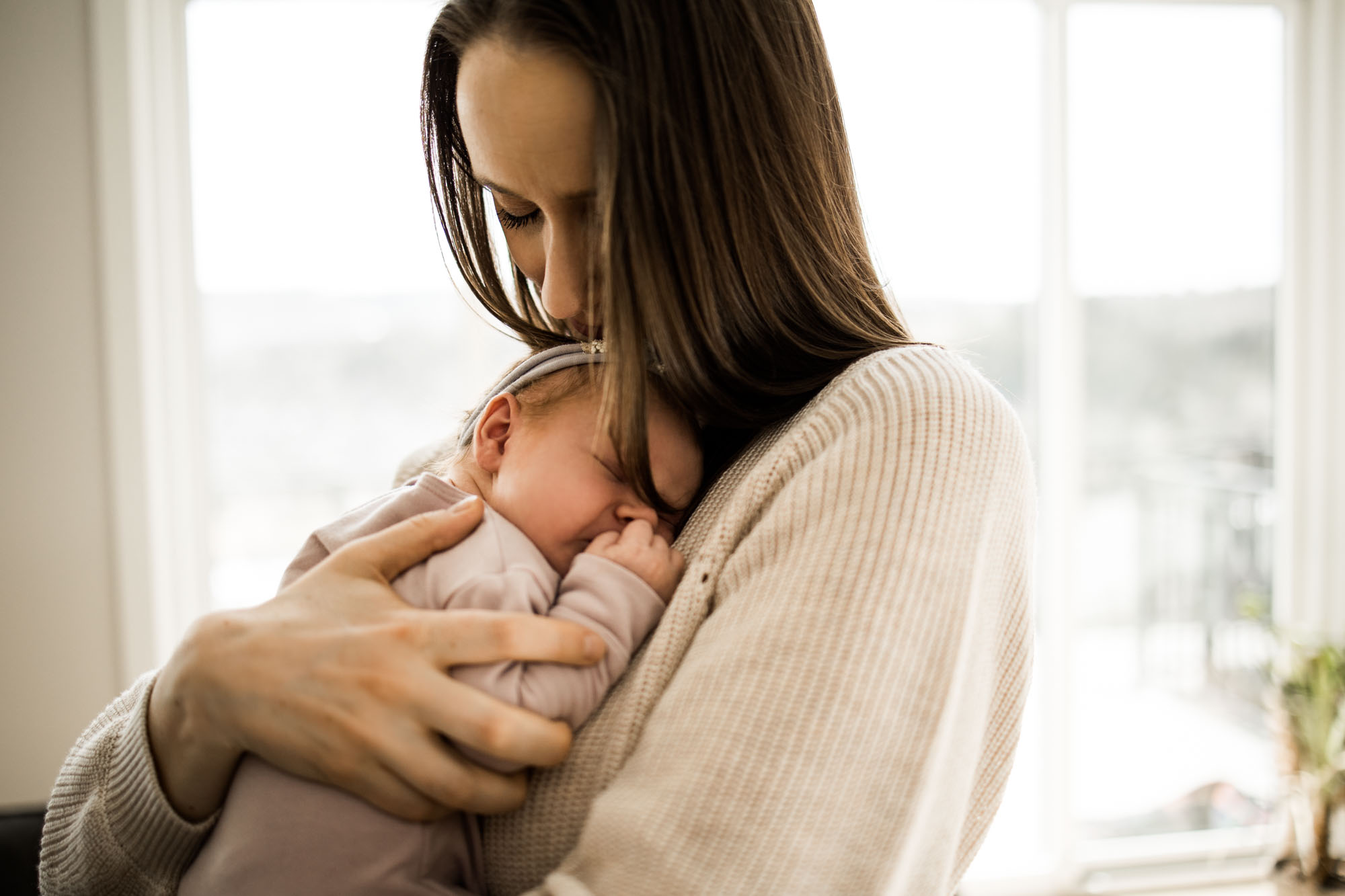 Calgary newborn and maternity photographer, in-home lifestyle photos with a family holding their newborn baby