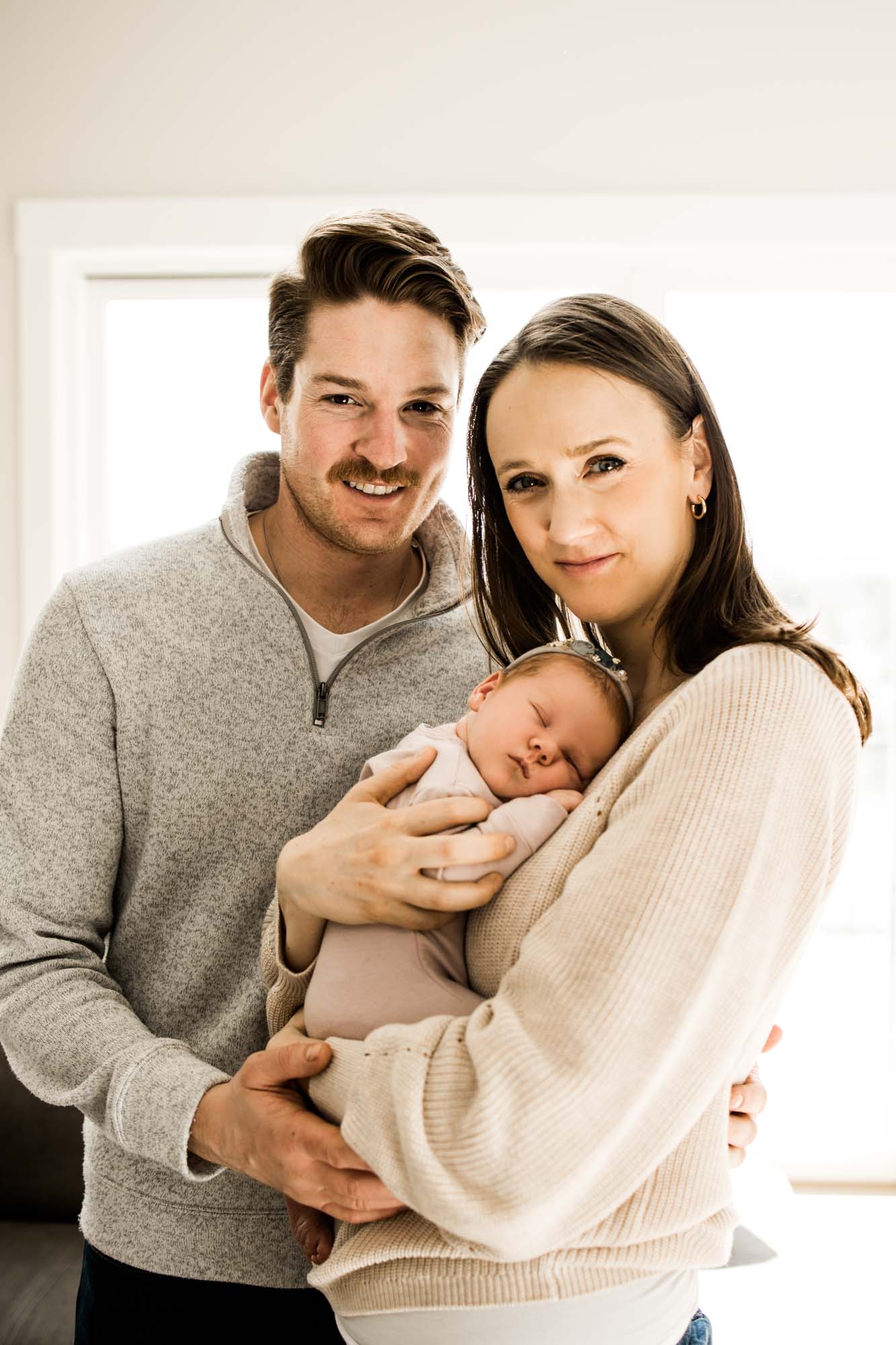 Calgary newborn and maternity photographer, in-home lifestyle photos with a family holding their newborn baby