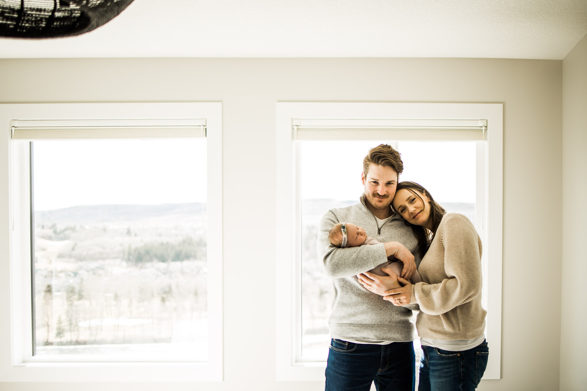 Calgary newborn and maternity photographer, in-home lifestyle photos with a family holding their newborn baby