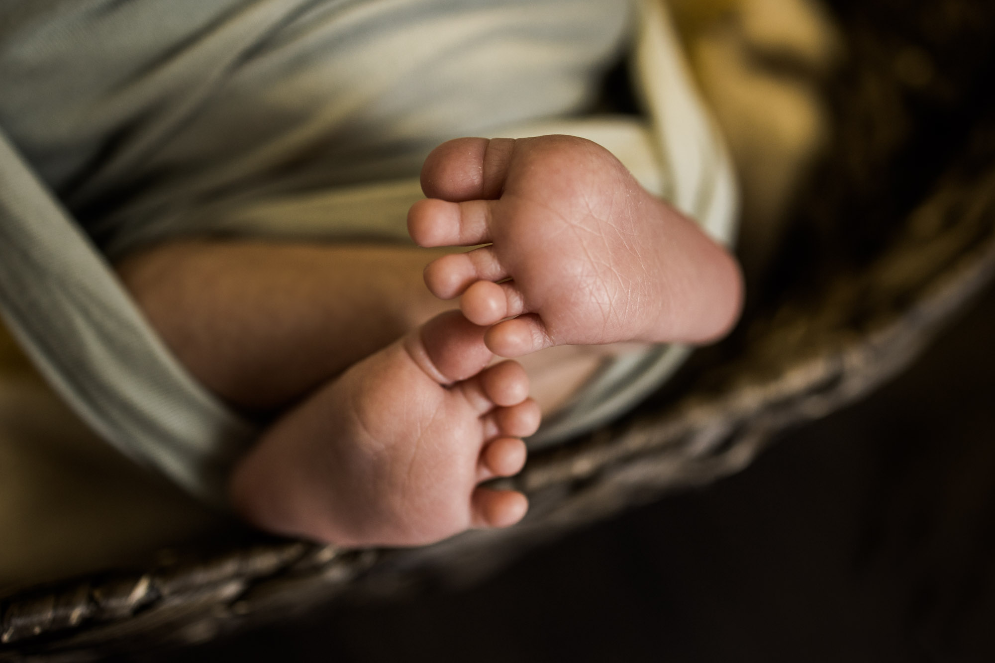 Calgary newborn and maternity lifestyle photographer, newborn baby in a basket during an in-home lifestyle newborn photo session