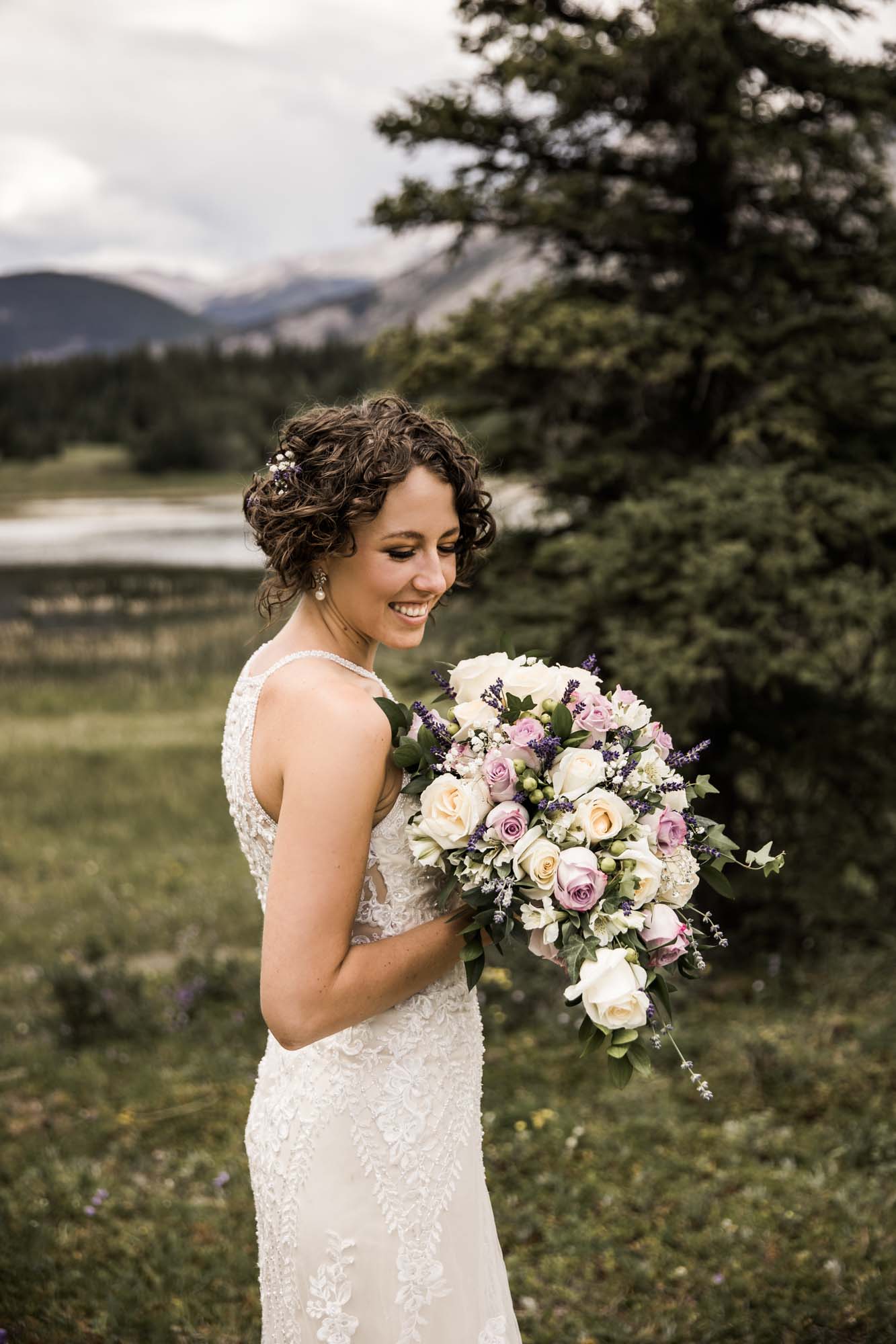 Calgary and Kananaskis Country wedding photographer, bride and groom for elopement photos in Kananaskis Country in front of water and mountains