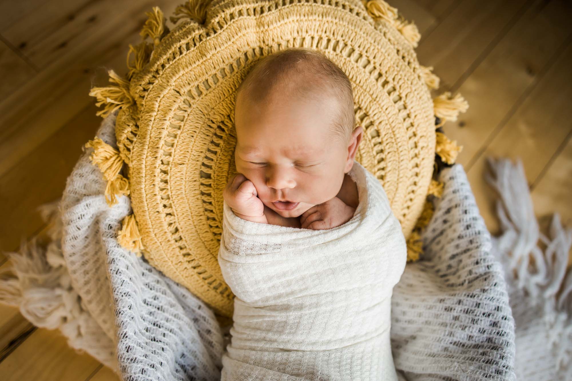 Calgary in-home lifestyle newborn photo of a newborn baby in a basket