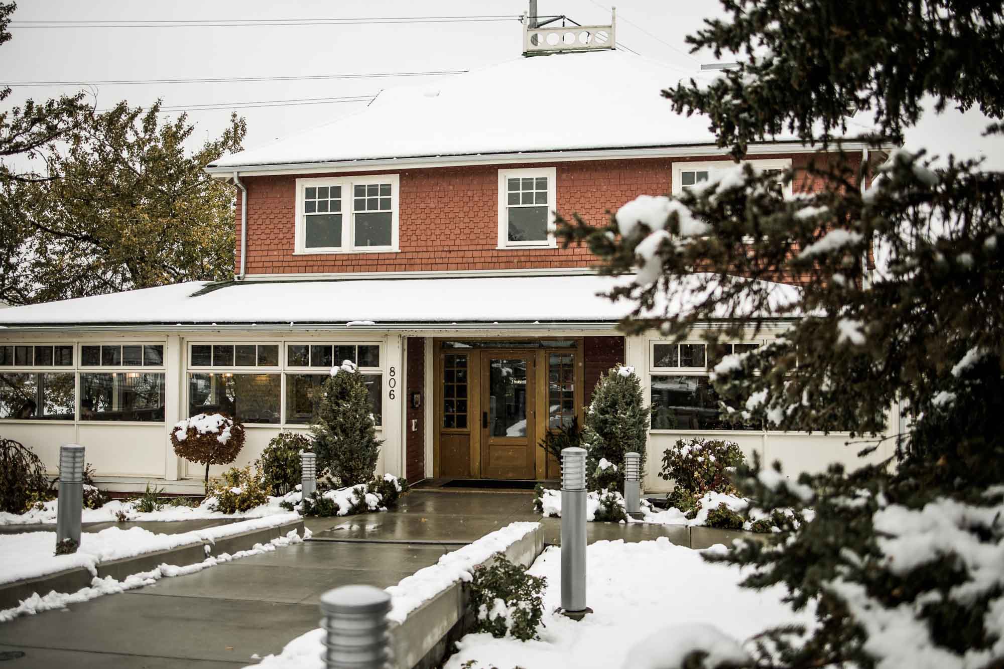 Calgary wedding photographer, bride in her dress with her bridal flowers and groom on their wedding day at Deane House Restaurant, intimate family dinner