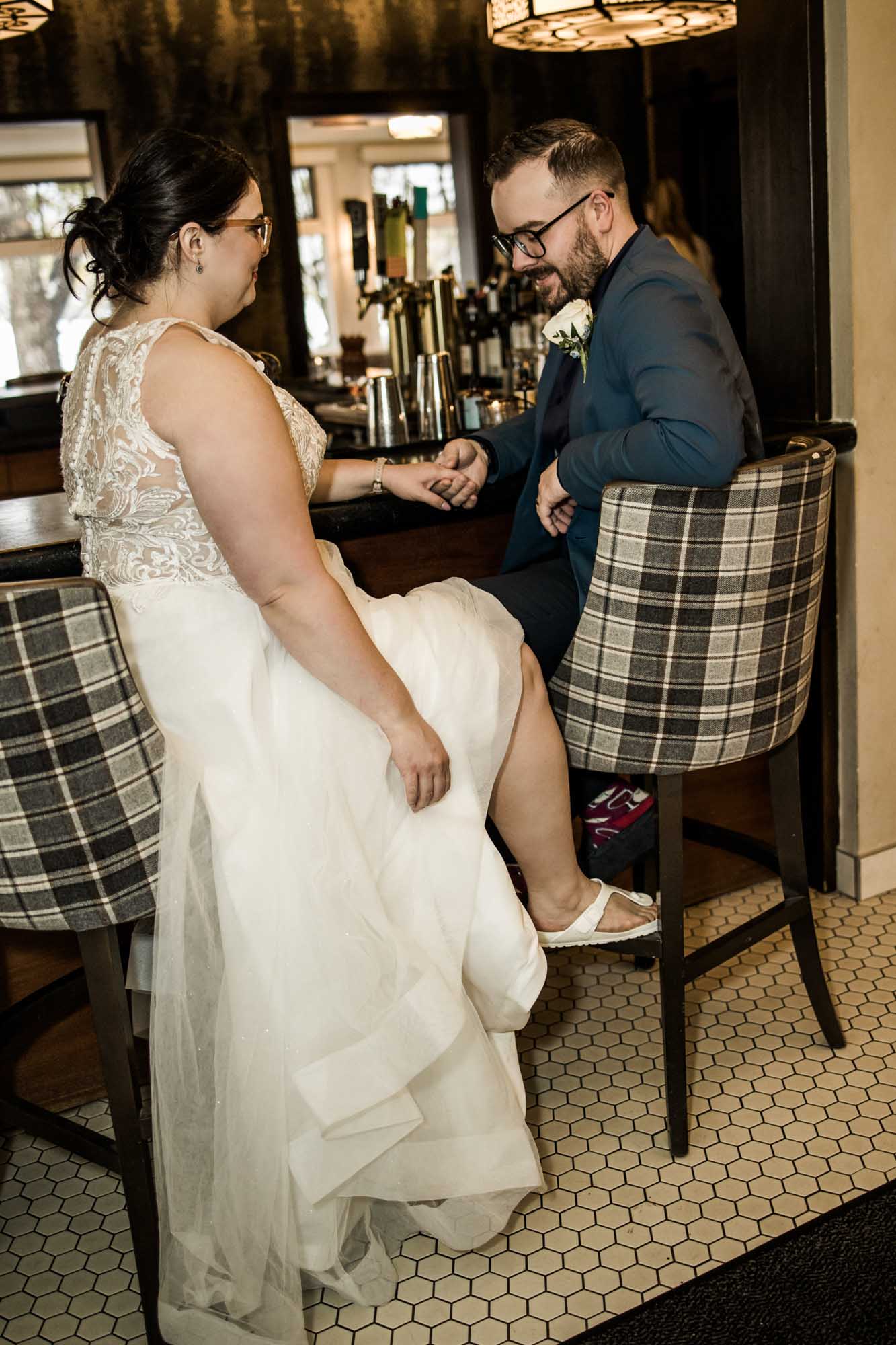Calgary wedding photographer, bride in her dress with her bridal flowers and groom on their wedding day at Deane House Restaurant, intimate family dinner