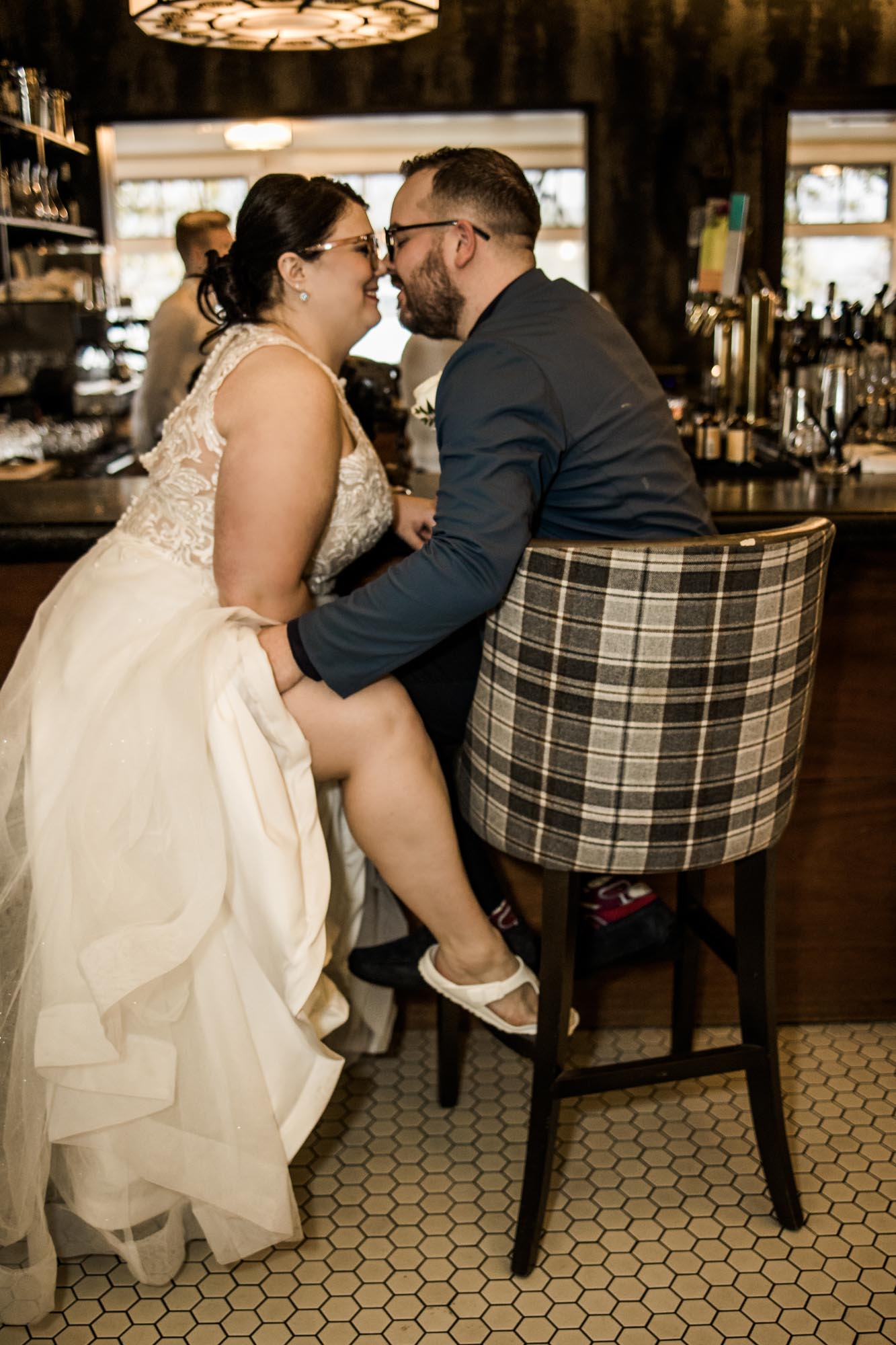 Calgary wedding photographer, bride in her dress with her bridal flowers and groom on their wedding day at Deane House Restaurant, intimate family dinner