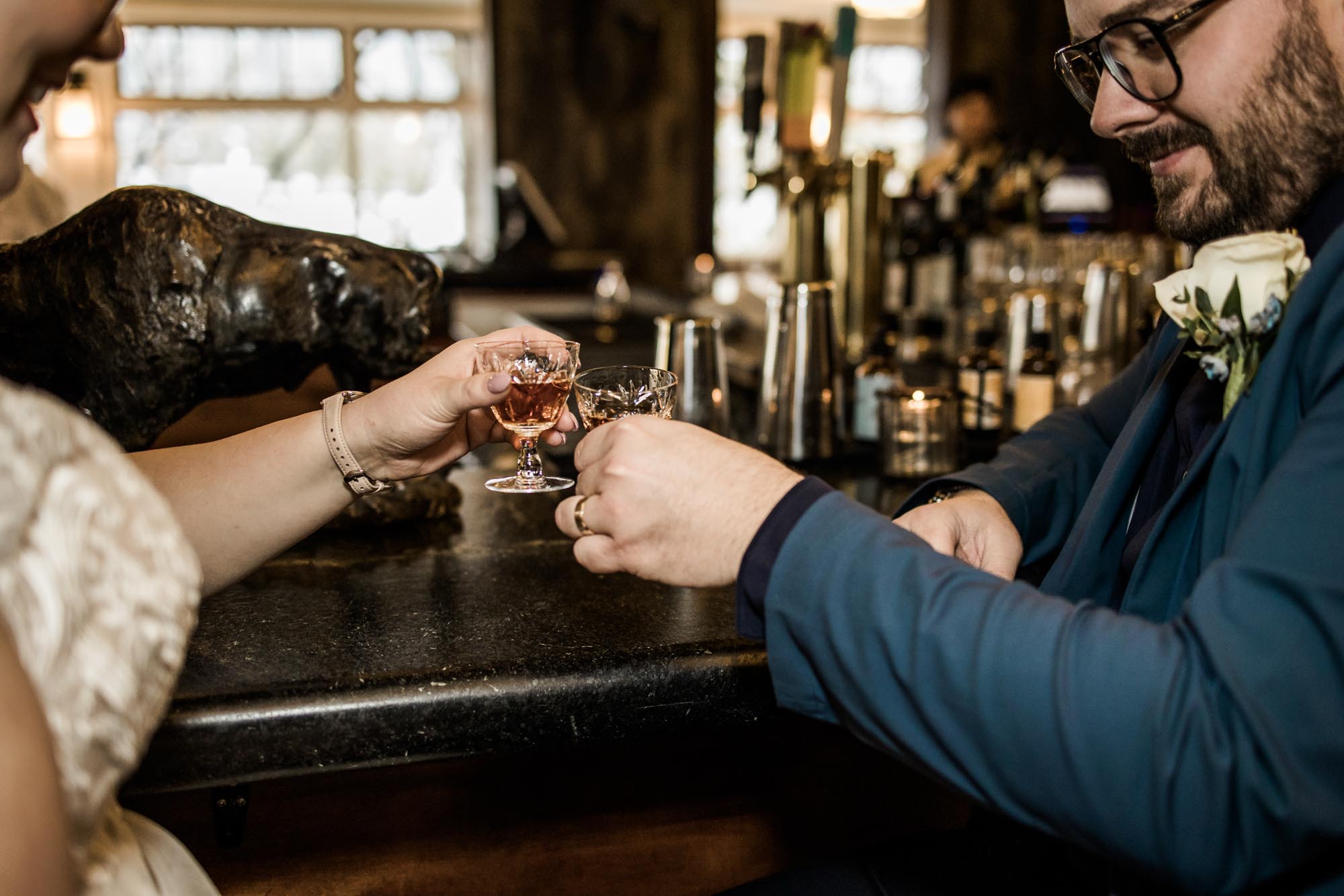 Calgary wedding photographer, bride in her dress with her bridal flowers and groom on their wedding day at Deane House Restaurant, intimate family dinner