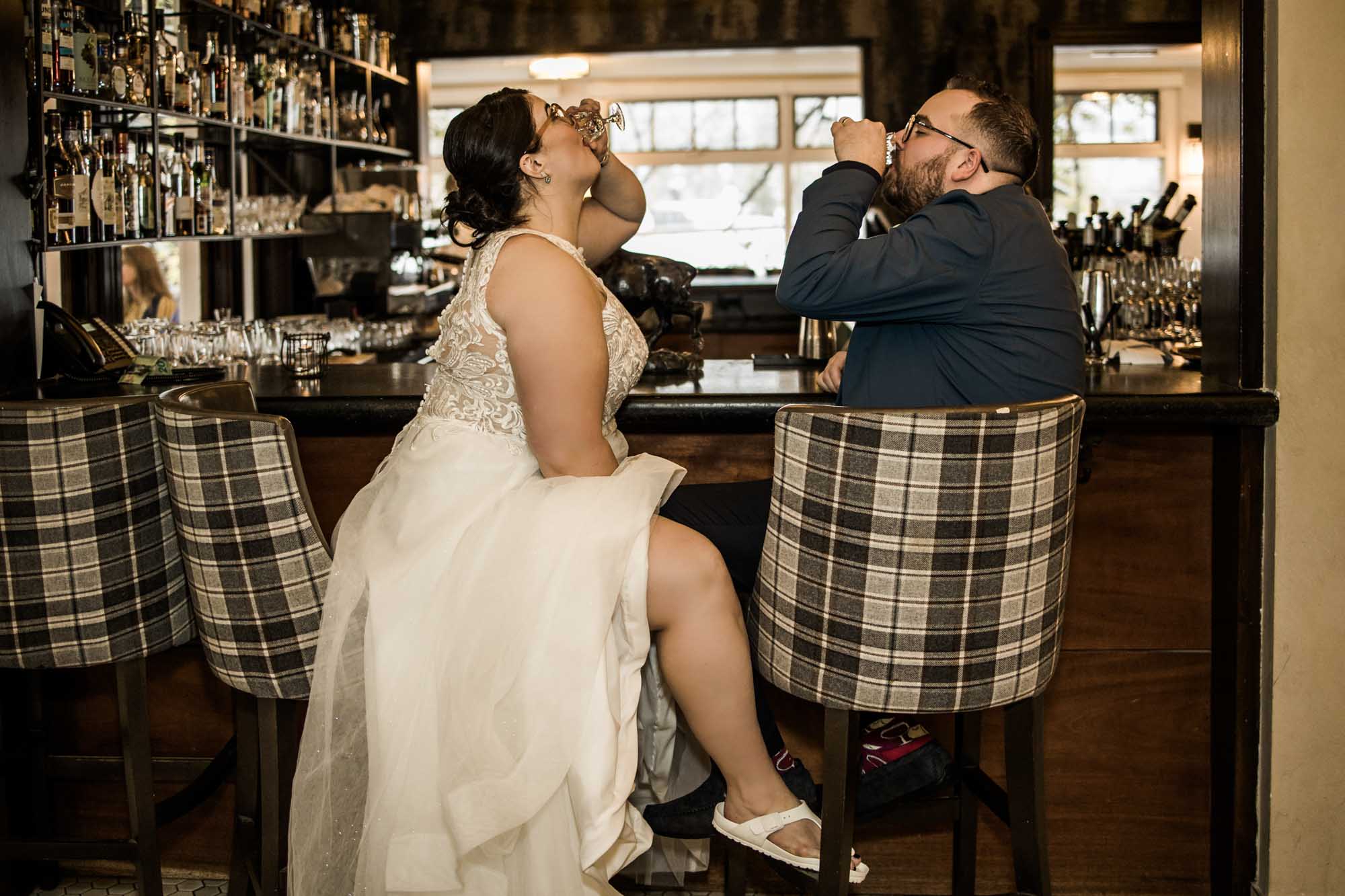 Calgary wedding photographer, bride in her dress with her bridal flowers and groom on their wedding day at Deane House Restaurant, intimate family dinner