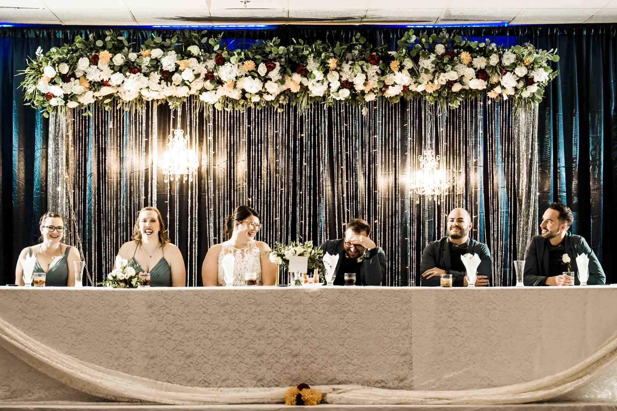 Calgary wedding photographer, bride in her dress with her bridal flowers and groom on their wedding day at White Diamond Conference Center, large wedding reception space