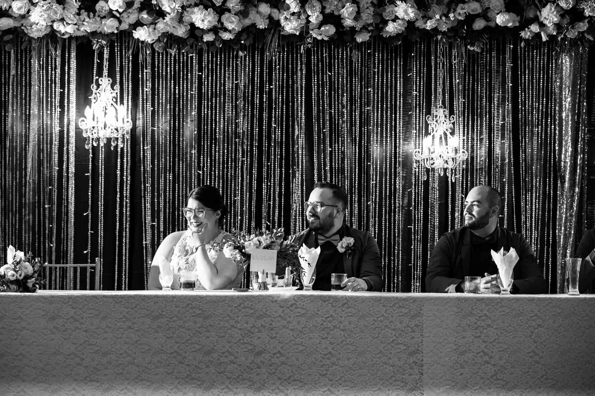 Calgary wedding photographer, bride in her dress with her bridal flowers and groom on their wedding day at White Diamond Conference Center, large wedding reception space