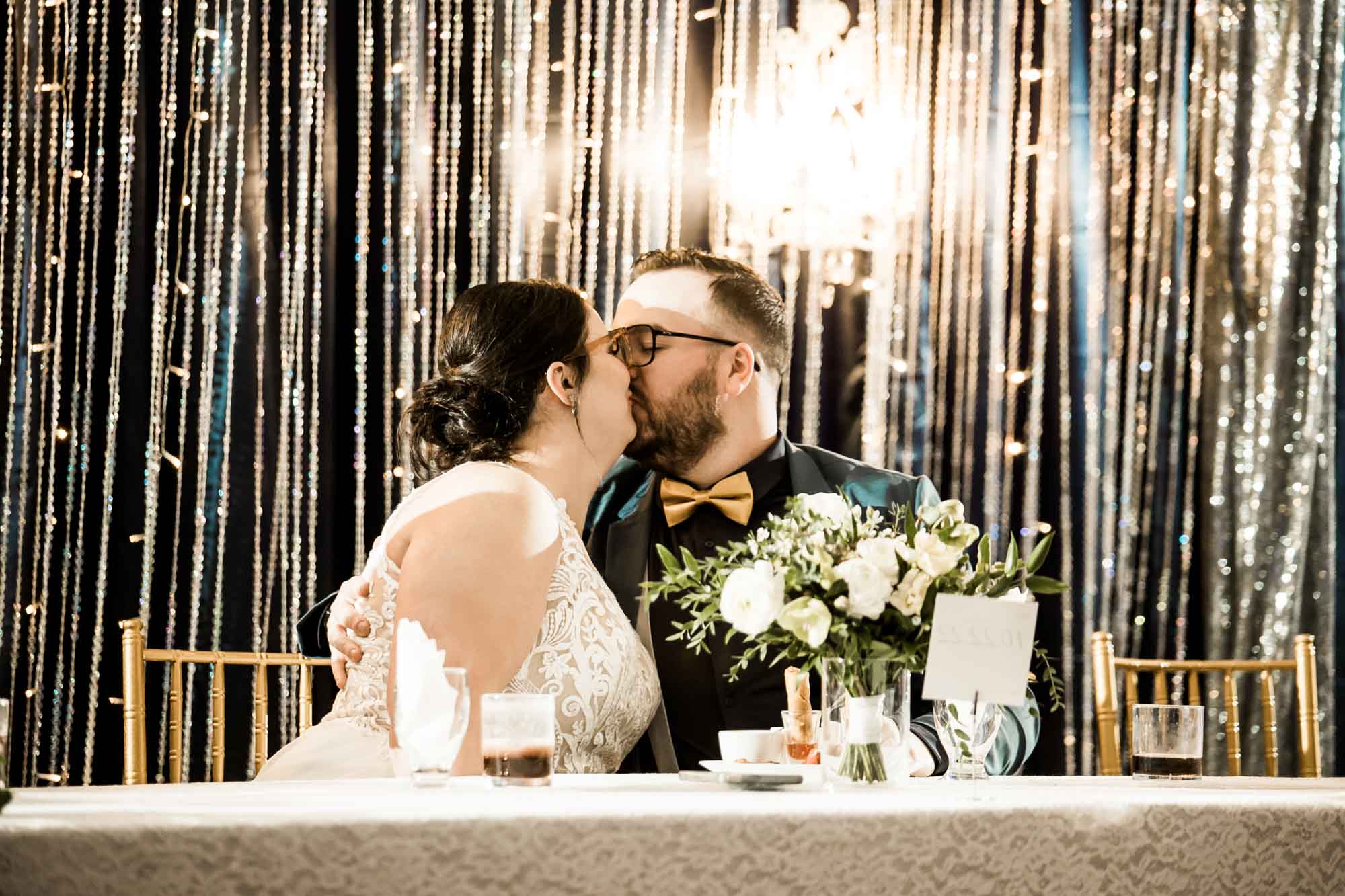 Calgary wedding photographer, bride in her dress with her bridal flowers and groom on their wedding day at White Diamond Conference Center, large wedding reception space