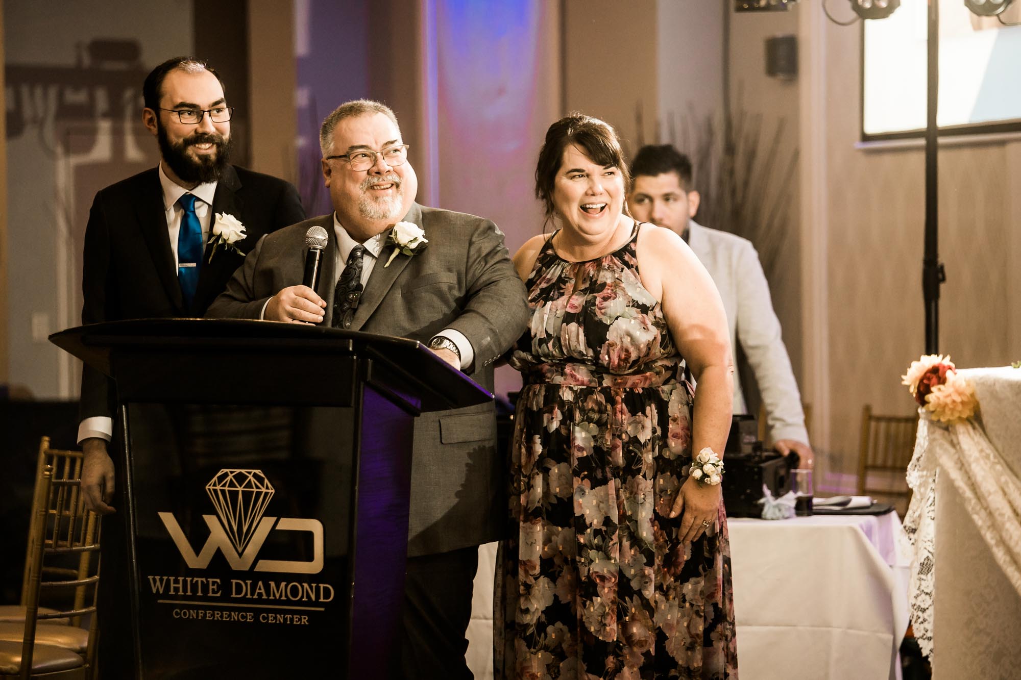 Calgary wedding photographer, bride in her dress with her bridal flowers and groom on their wedding day at White Diamond Conference Center, large wedding reception space