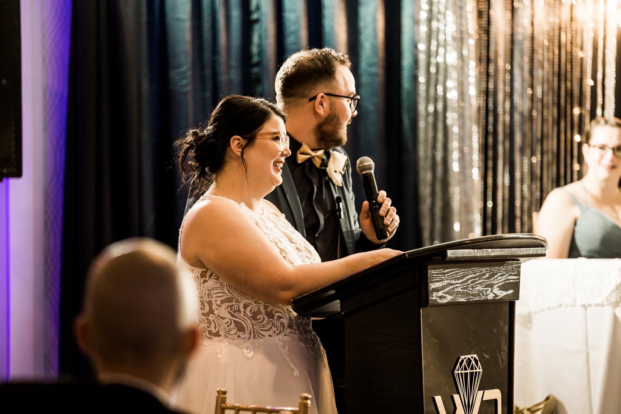 Calgary wedding photographer, bride in her dress with her bridal flowers and groom on their wedding day at White Diamond Conference Center, large wedding reception space