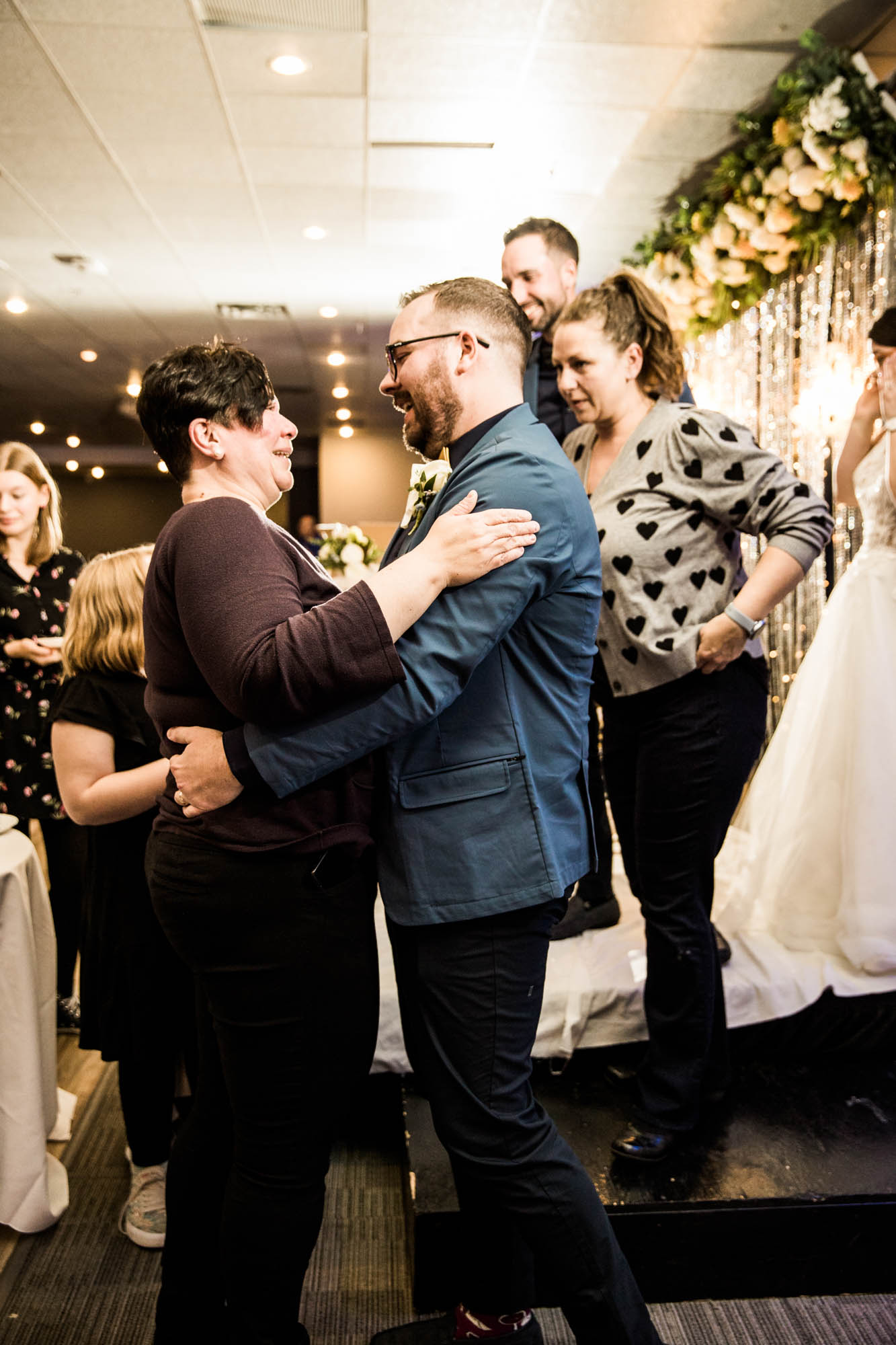 Calgary wedding photographer, bride in her dress with her bridal flowers and groom on their wedding day at White Diamond Conference Center, large wedding reception space