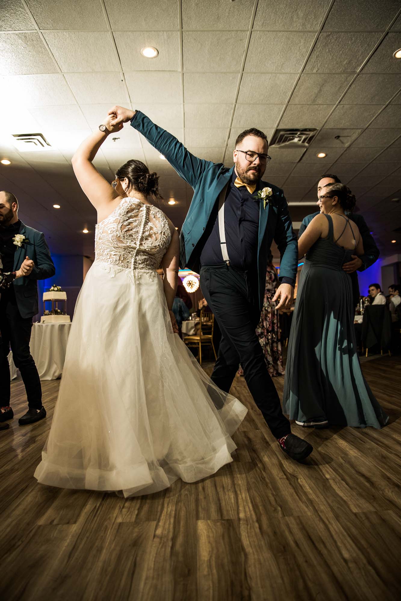 Calgary wedding photographer, bride in her dress with her bridal flowers and groom on their wedding day at White Diamond Conference Center, large wedding reception space