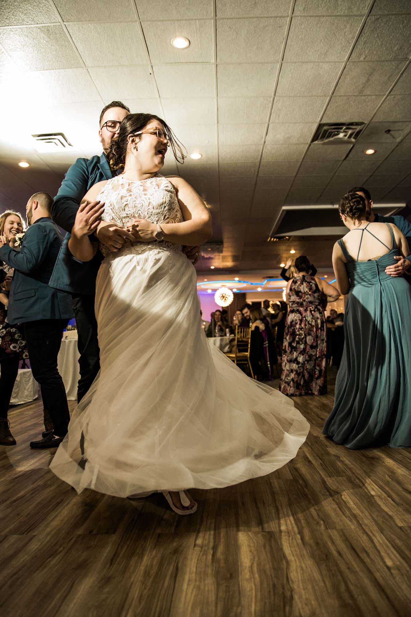 Calgary wedding photographer, bride in her dress with her bridal flowers and groom on their wedding day at White Diamond Conference Center, large wedding reception space