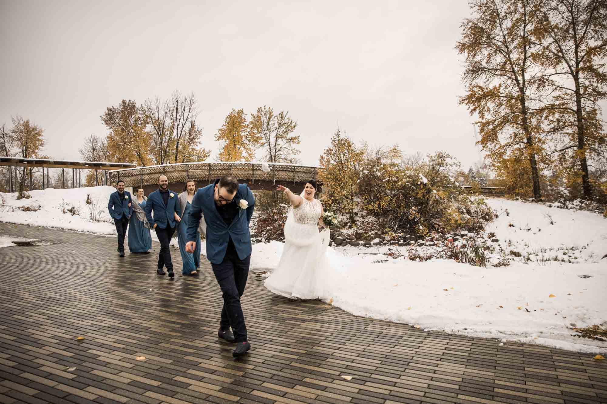 Calgary wedding photographer, bride in her dress with her bridal flowers and groom on their wedding day at St Patrick's Island, winter snow and fall leaves