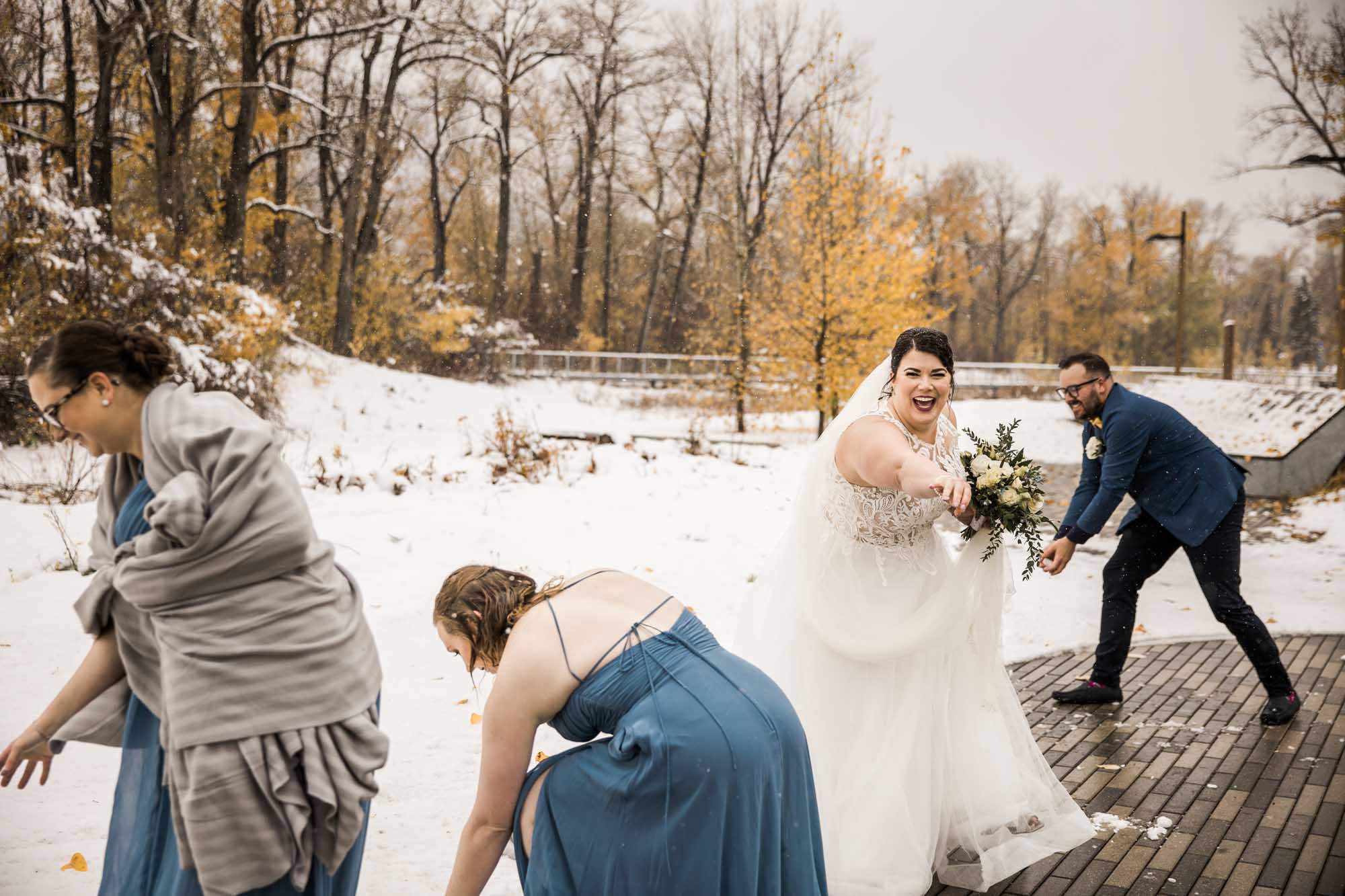 Calgary wedding photographer, bride in her dress with her bridal flowers and groom on their wedding day at St Patrick's Island, winter snow and fall leaves