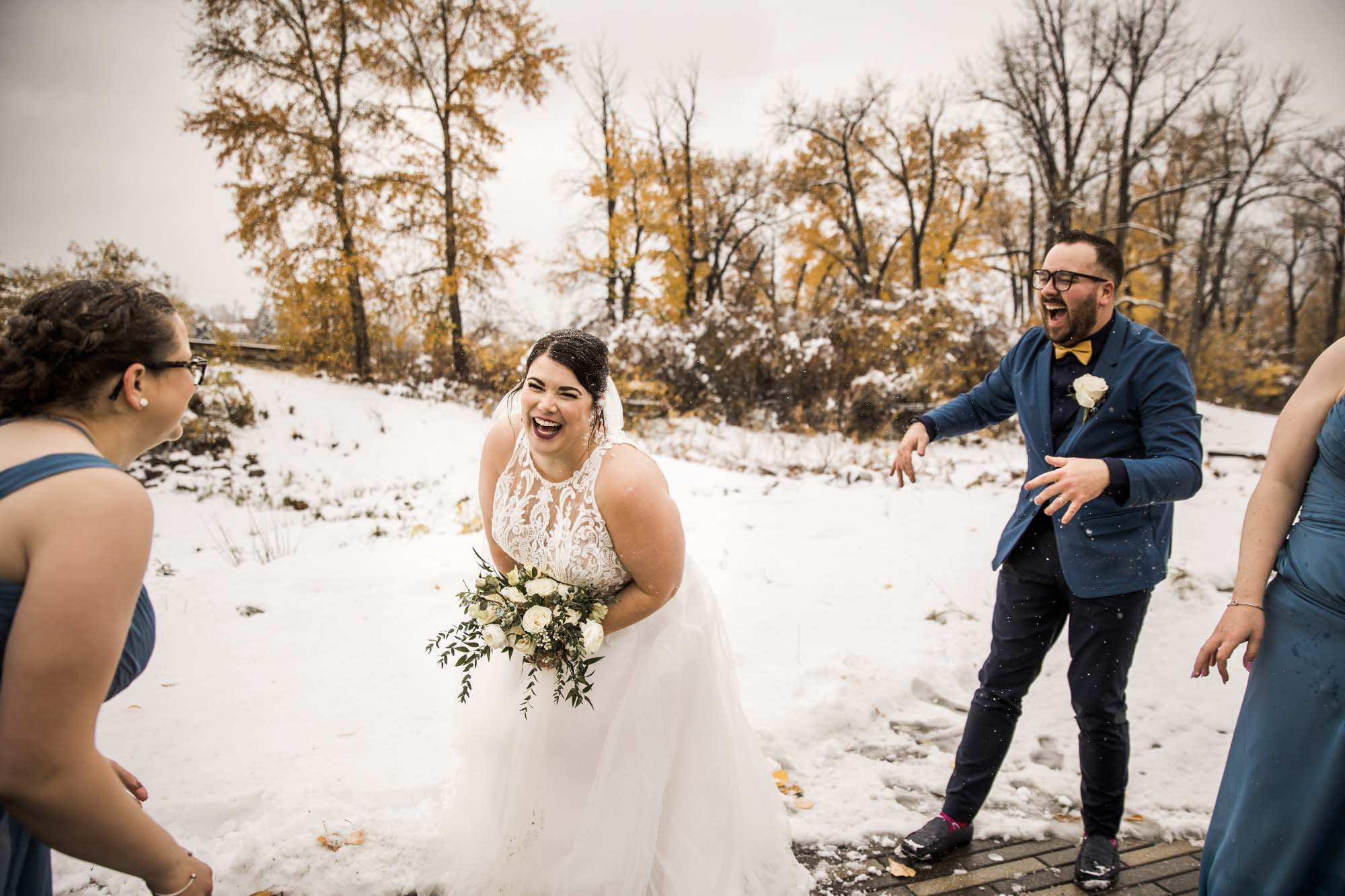 Calgary wedding photographer, bride in her dress with her bridal flowers and groom on their wedding day at St Patrick's Island, winter snow and fall leaves