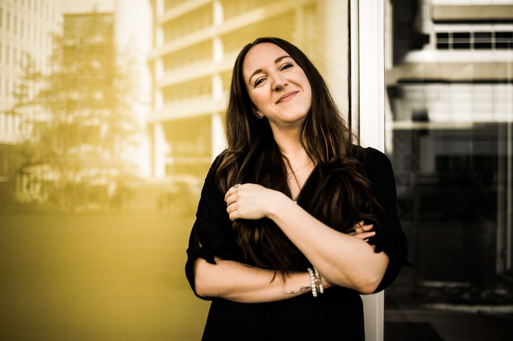 Calgary branding and headshot photographer, copywriter posing for her headshots and branding photos at downtown in the spring