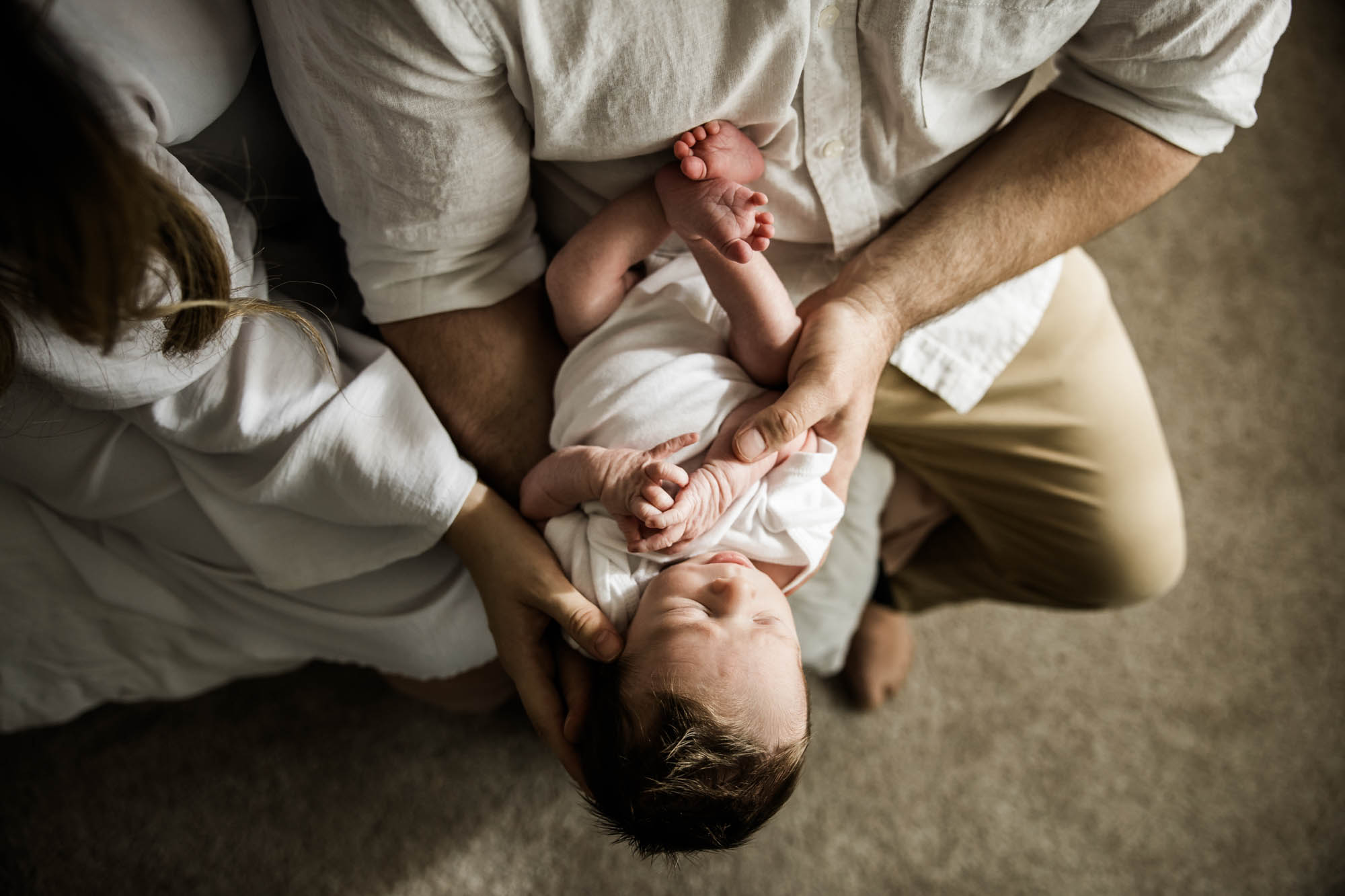 Calgary lifestyle newborn and maternity photographer, family in their home during a newborn photo session with their new baby, lifestyle photos and posed basket photos